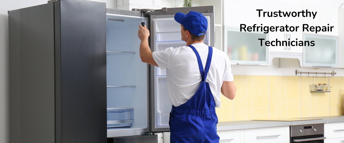 A refrigerator technician in uniform checking and repairing a fridge in a kitchen.